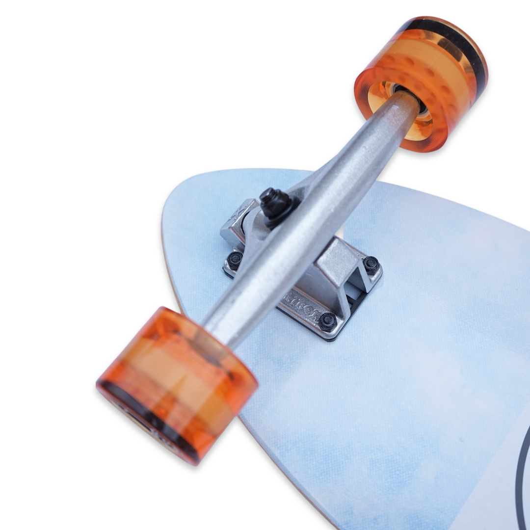 Close up view of orange colored skateboard wheels mounted on a truck on a 30" blue cruiser style skateboard